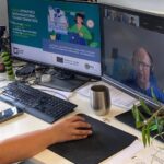 Forscherin präsentiert virtuell ihre GenAI-Studie während einer hybriden Konferenzsitzung.